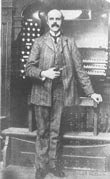 hollinsstand Alfred Hollins standing at an organ console